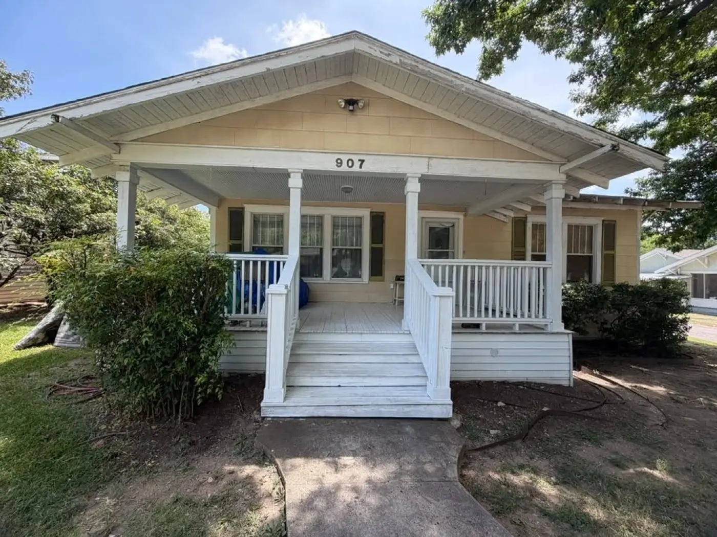 Yellow bungalow with a covered front porch, bought by Tara Pays Cash