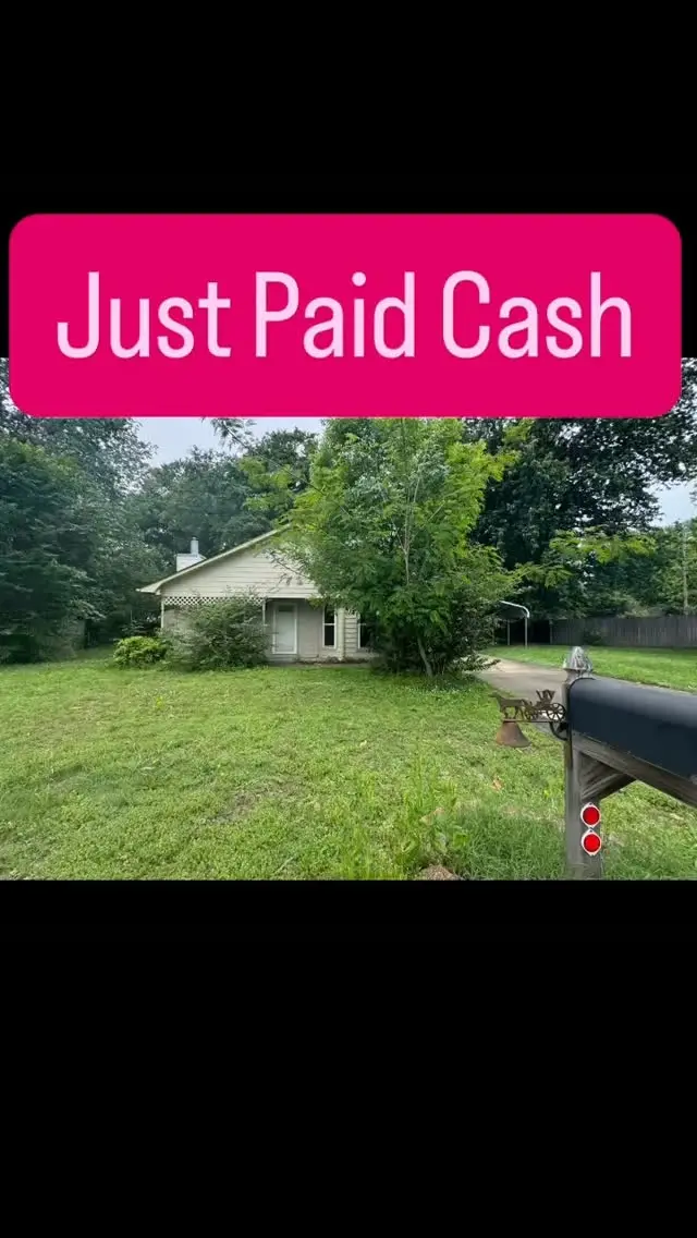 A single-story house with a Just Paid Cash banner